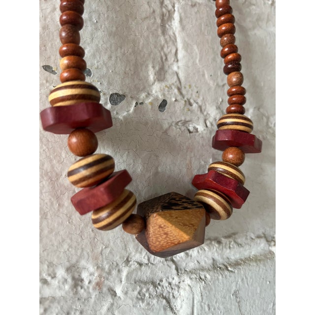 Vintage 1970s chunky Bohemian beaded necklace made from mixed wood. Features oversized geometric beads in layered tones of...