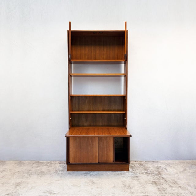 Constructed in teak veneer over a solid carcass, this Form 5 wall unit shows the recessed edge detailing and flush door...