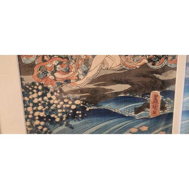 A framed mid-19th-century Japanese woodblock triptych print titled "Lovers Separated by a Stream" by master printmaker by...