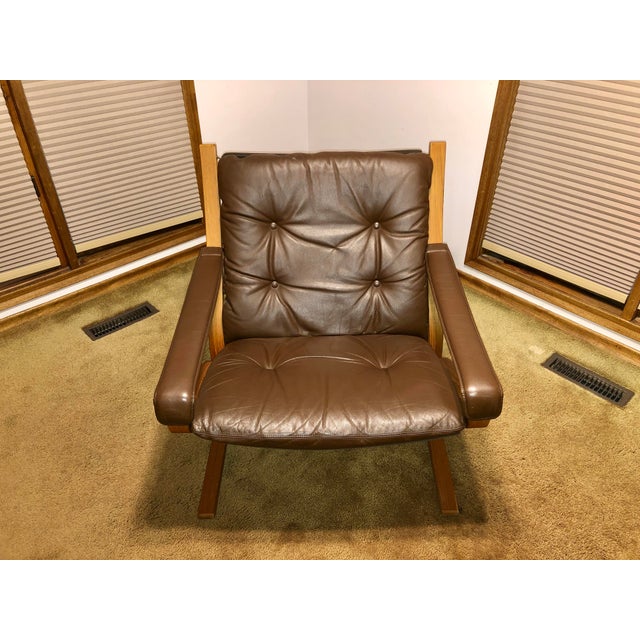 Two authentic Ingmar Relling Siesta armchairs with leather cushions and teak frames. The chair frames, frame fabric, and...