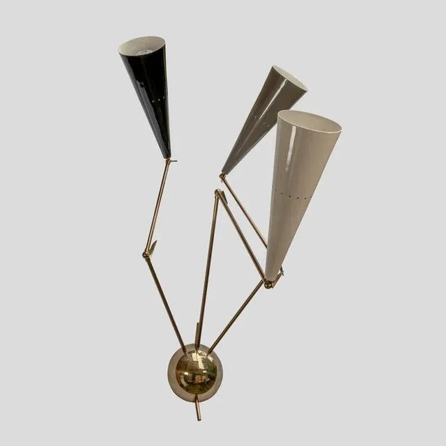 Pair of reale wall lights. Black, cream and grey color movable shades (up, down, forward and backwards movements) on brass...