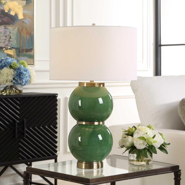 The Banner Table Lamp Showcases Two Large, Stacked Spheres Finished In A Moss Green Glaze, Accented With Antique Brass...