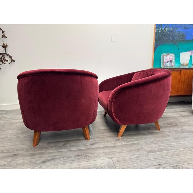 Pair of Italian 1960s club chairs newly upholstered in fine Ruby velvet . Additional cushions are included.