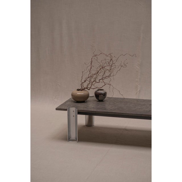 Distinctive architectural coffee table from the 1970s, combining a richly textured natural stone top with a polished...