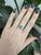 A rare Paraiba color tourmaline takes centre stage in an electric blue-green at the heart of this solid 14K white gold...