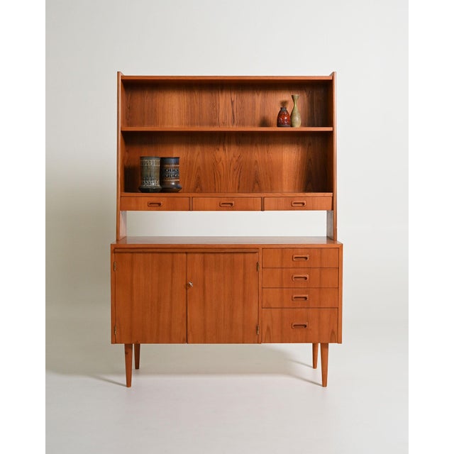 Teak bookcase with pull-out shelf, storage compartment, and integrated drawers. Scandinavian production, 1960s. Designed...
