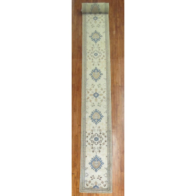 A long and narrow rare size early 20th century antique Oushak runner. Accents in blue, goldenrod soft green accents, circa...