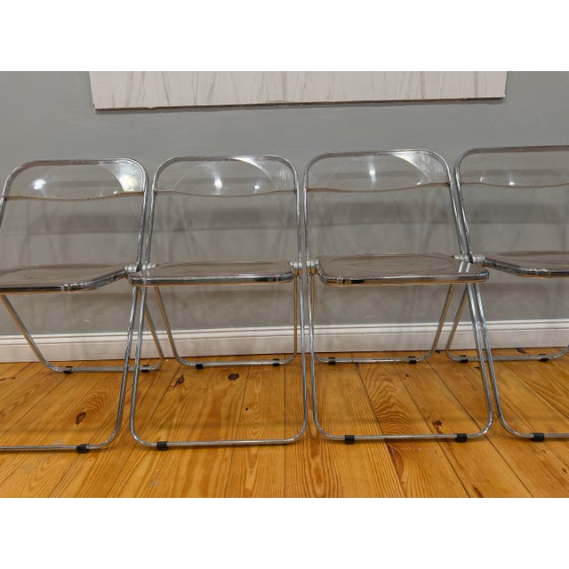 Four original Castelli Italy lucite folding chairs. The chairs are marked “pl/a CASTELLI ITALY” and are associated with...