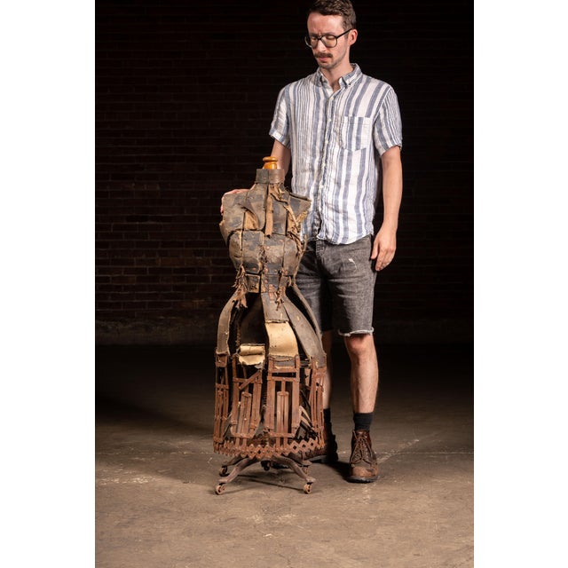 Early adjustable dress form constructed with a collapsible iron cage skirt mechanism, papier-mâché body, and rolling cast...
