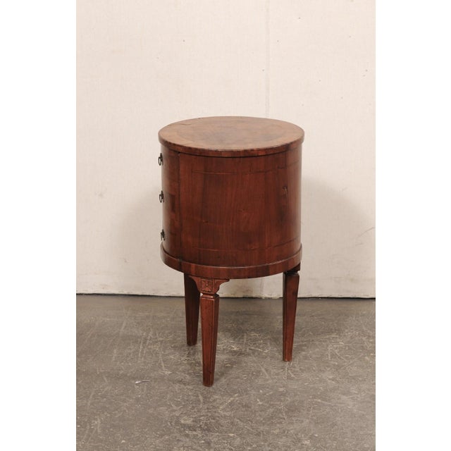 A French wooden cylindrical side chest with storage from the mid 20th century. This mid-century chest from France has a...