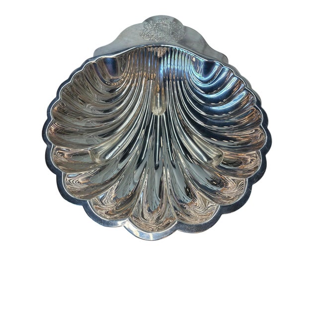 A silverplate scallop shell dish with real presence — deep fluted ribs that catch the light and a scalloped edge straight...