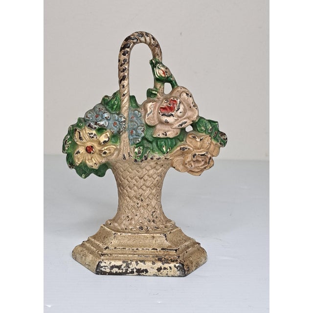 A charming and highly collectible Hubley Manufacturing Co. #152 "Basket of Flowers" cast iron doorstop, featuring a...