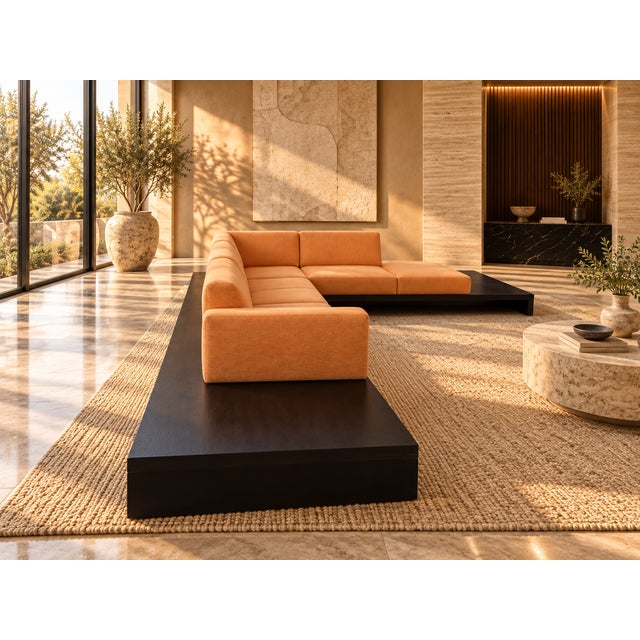A striking three-piece modular sectional sofa defined by its sculptural silhouette, warm terracotta-orange upholstery, and...