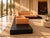 A striking three-piece modular sectional sofa defined by its sculptural silhouette, warm terracotta-orange upholstery, and...