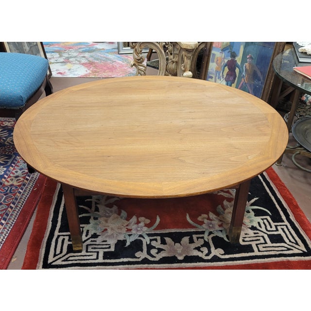 Fine vintage walnut round mid century modern coffee table with brass feet. Measures 38 inches in diameter and stands 14...