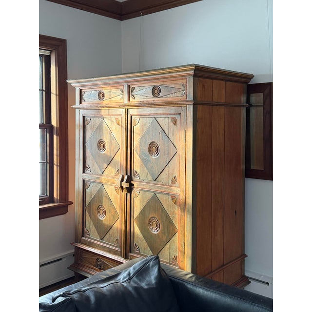 A hand painted, hand carved, Indonesian armoire made of teak. Carved throughout with a diamond motif, decorated with...