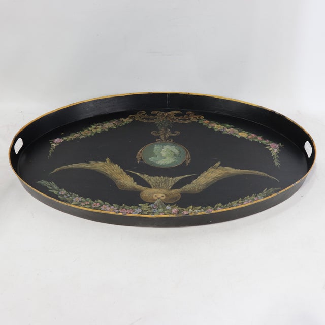 This elegant vintage oval tole tray is finished in a deep black lacquer and features a sophisticated hand-painted...