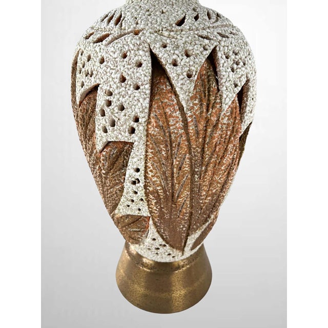 A pair of Mid-Century lamps with lava glaze and incised leaves to allow light leakage. The lamps embrace Hollywood Regency...