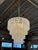 Elegant Italian chandelier featuring four cascading tiers of textured glass panels supported by a brass frame. The...