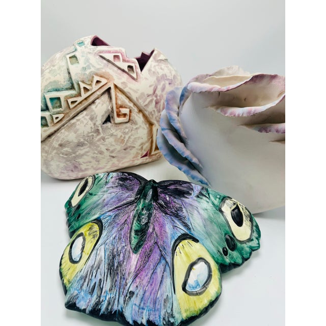 This is a ceramic vessel designed to resemble a blooming rose or cabbage flower. The piece has a sculptural quality, with...