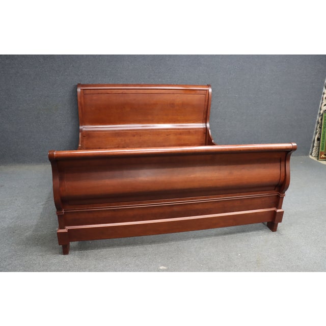 Solid Cherry king sleigh bed by Martin’s Furniture, featuring a classic rolled headboard and footboard with rich, warm...