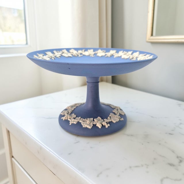 A classic Wedgwood Jasperware pedestal compote executed in the firm’s signature matte blue stoneware with applied cream...