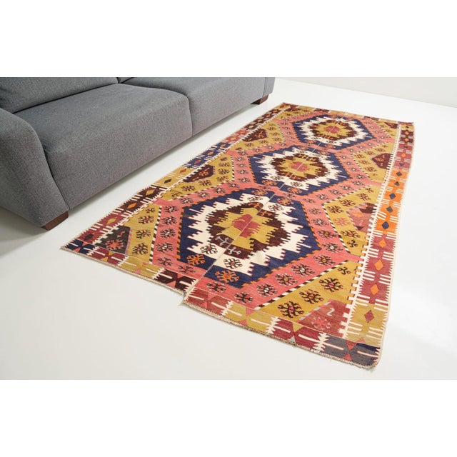This is a vintage Turkish Oushak rug from the Mid 20th Century. The piece was hand-knotted.