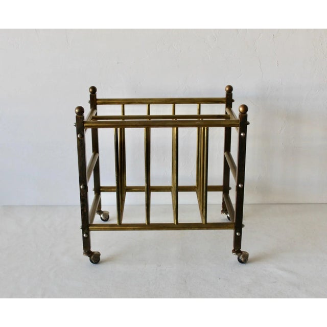 Brass Canterbury magazine rack, of squared and tubular brass construction with hooded ball coaster feet, and sphere...