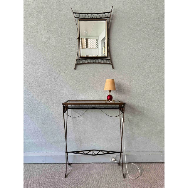A striking mid-century Italian console and mirror set from the 1950s, crafted from patinated brass, hand-wrought iron, and...