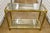 Stunning Hollywood Regency Brass Console in the style of Mastercraft. An inset glass top and bottom shelf provide a...