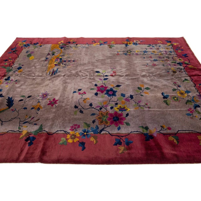 A stunning antique Art Deco Chinese hand-knotted wool rug featuring a brown color field and a frame of red and multicolor...