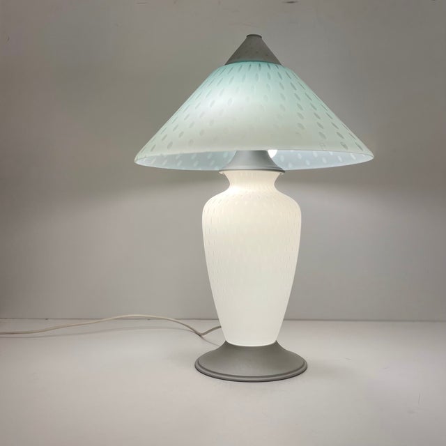 Italian table lamp in white bubbled Murano glass and frosted silver metal designed in the 1980s. This large lamp has two...