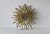 Vintage beveled gilt metal starburst mirror in the Hollywood Regency style, featuring a round central beveled mirror...