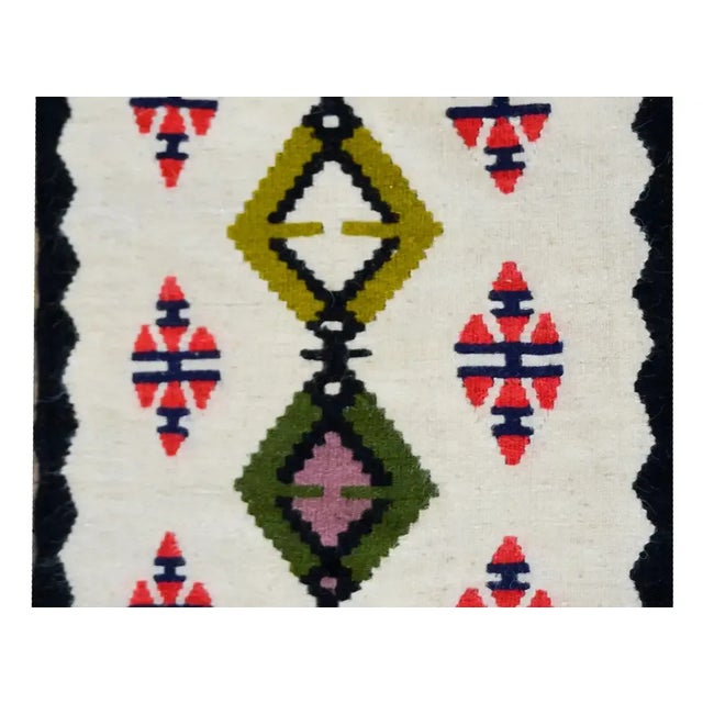 A striking vintage Navajo style rug with several diamonds running the length and living amidst a field of more diamond...