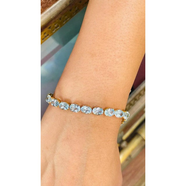 This is part of Chairish’s Fine Jewelry assortment. This Sparkling Blue Topaz Tennis Bracelet in 18K gold showcases 25...