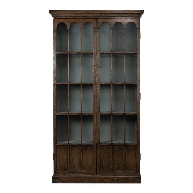 Tall glazed doors and a stepped crown give the display case its architectural presence. A pair of full-height glazed doors...