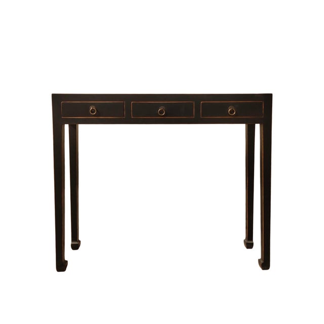 This vintage console table features three side-by-side storage drawers, each accented with traditional metal hardware and...