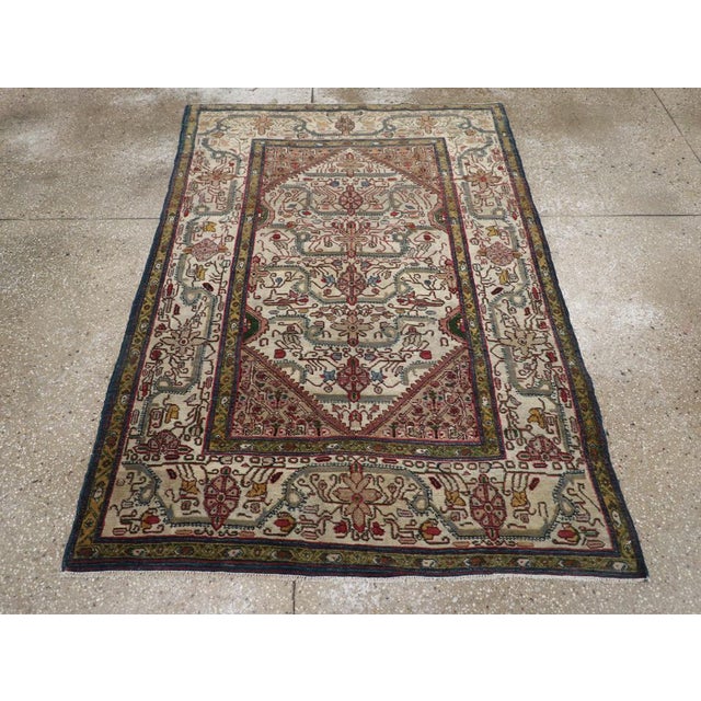 An antique Indian Agra accent rug. The decoration both of the ivory subfield and the matching ivory border of a twisted,...