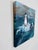 Acrylic painting depicting two inflatable emperor penguin chicks positioned on a small iceberg within a cold marine...