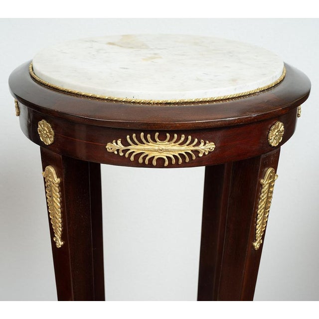 Pair of Napoleon III pedestals in mahogany featherbed with a marble top and gilded bronze inserts. The circular white...