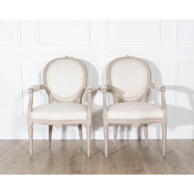A refined pair of Gustavian style armchairs from Sweden, dating to the early 20th century and crafted in the neoclassical...