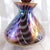 This is a mostly purple but rainbow color iridescent perfume bottle with a matching stopper. The bottle is not marked or...