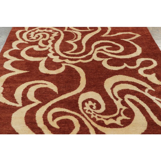 This contemporary 6x8 Mid-Century Modern rug, features sweeping abstract scrollwork in rust and ivory. Hand-knotted in...