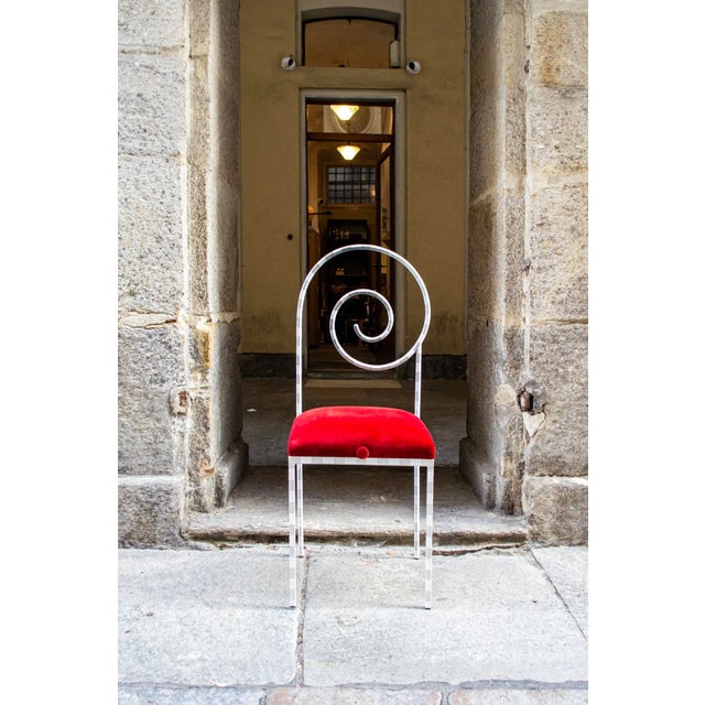 Chair with lacquered metal frame and padded seat upholstered in red velvet. Suspiral model Designer Luigi Serafini...