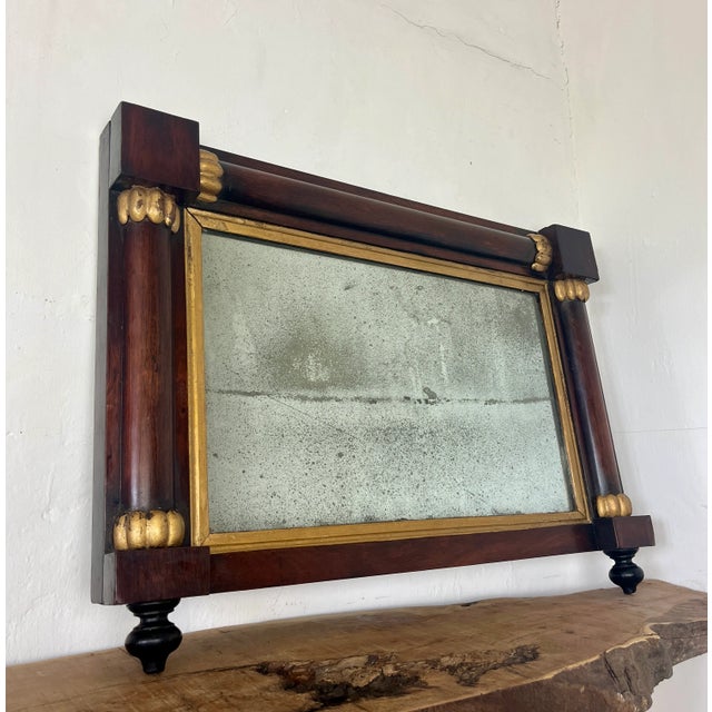 A mid-19th-century overmantle mirror in landscape form, the frame has classical columns to the sides, and top with gilt...