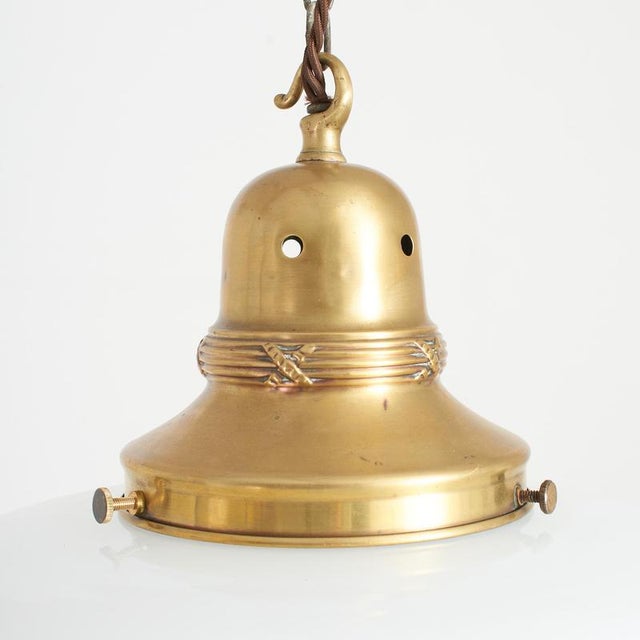 An original opaline glass pendant light. The light has a milk glass opaline shade and retains its original brass hanging...