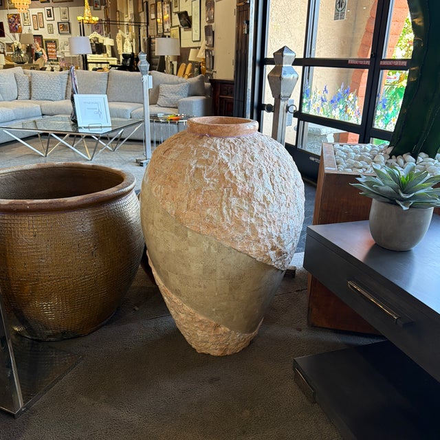 A striking tan urn-style tessellated stone floor vase with a unique mix of smooth and textured surfaces. Its sculptural...
