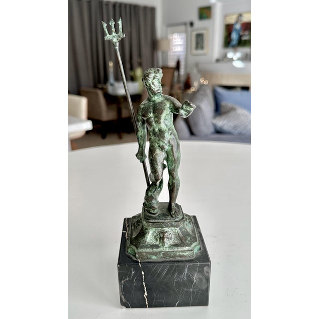 Smaller scale bronze statue depicting the Greek god Poseidon (or Roman god Neptune) holding his signature trident. The...