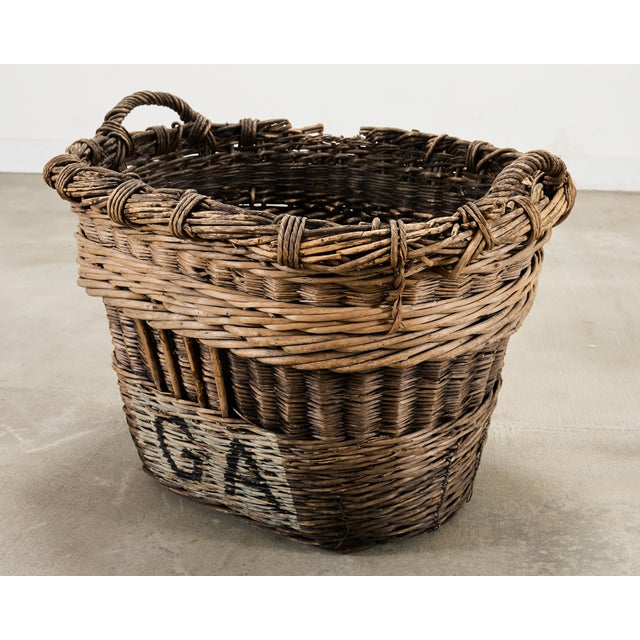 A large and beautifully weathered handwoven French vineyard Champagne grape wine harvest basket in thick woven wicker,...