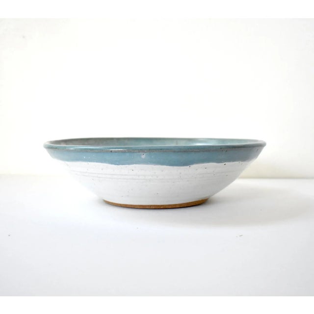 A studio or art pottery ceramic earthenware bowl, with a white speckled glaze and a blue border. Marked on the base. Light...